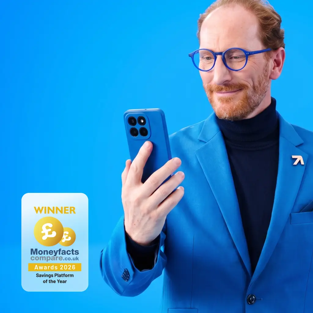 Spokesperson wearing a blue suit looking down at his smartphone screen against a bright blue background.