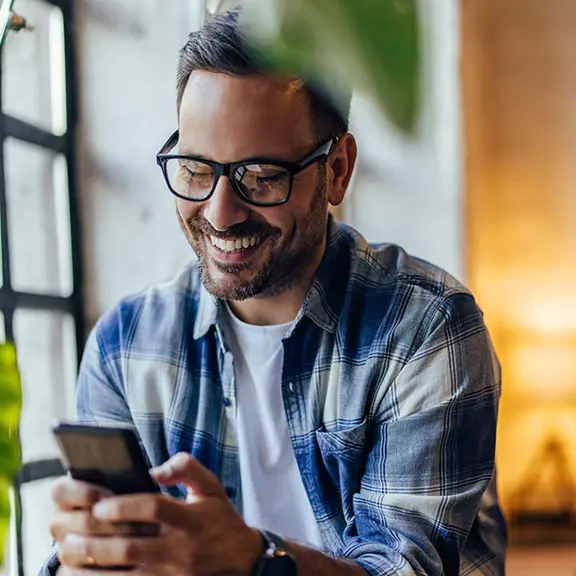 Hombre con gafas mirando el móvil.