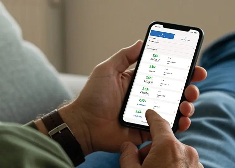 A pair of hands holding a phone displaying interest rates